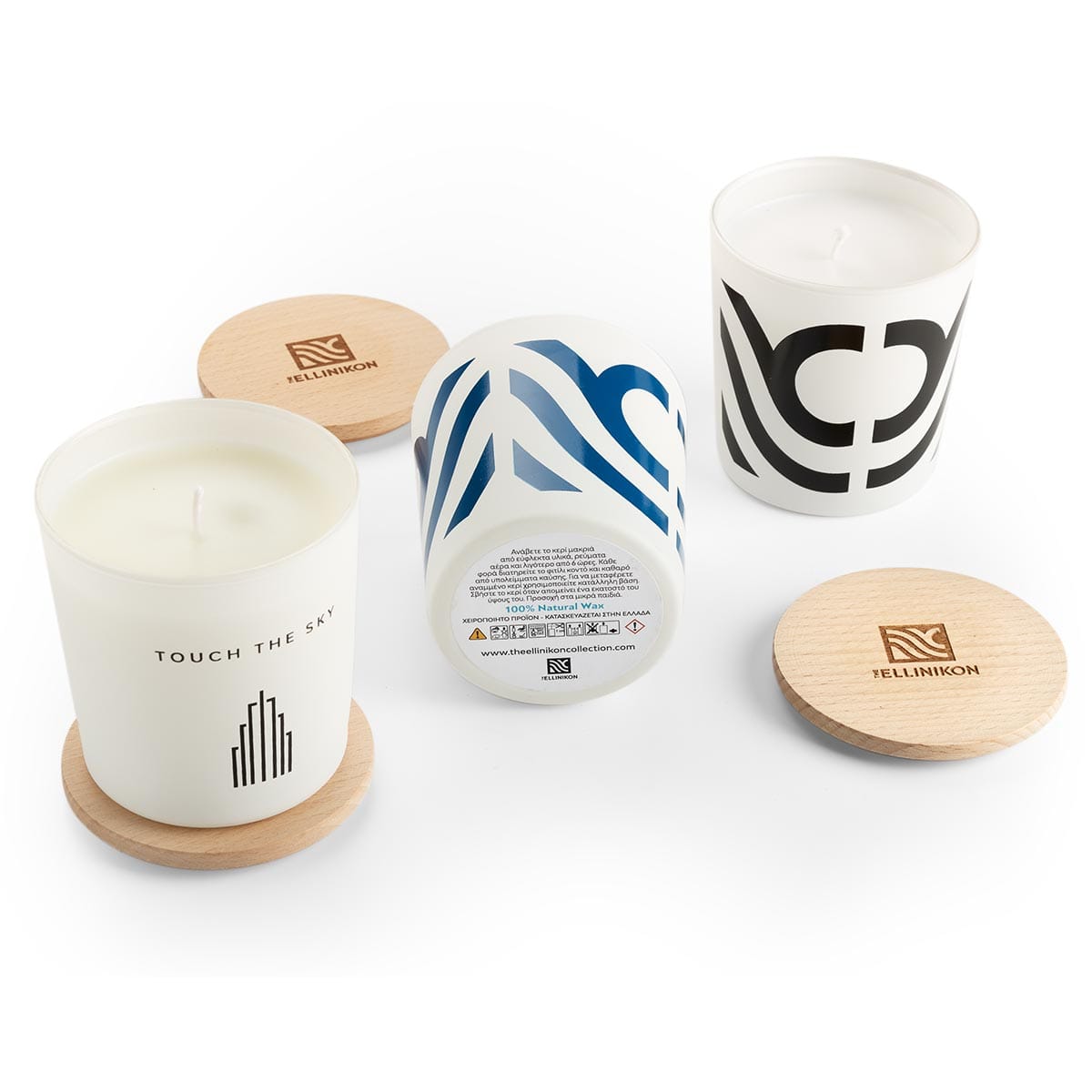 Τρία αρωματικά κεριά με διαφορετικά σχέδια και καπάκια.