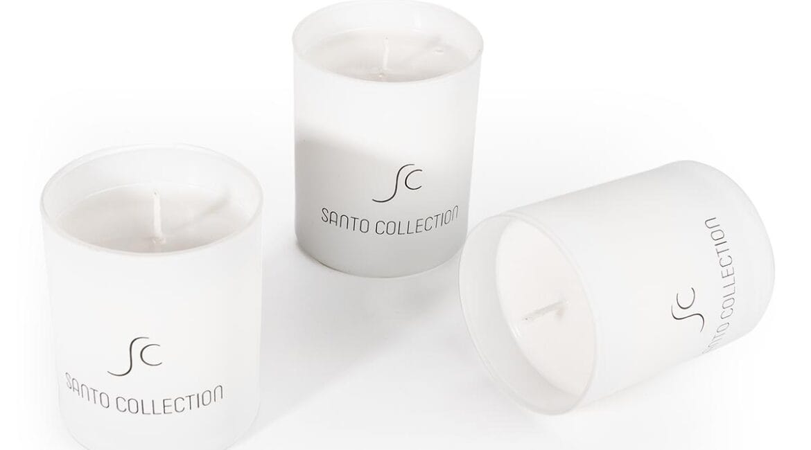 Τρία λευκά κεριά με το λογότυπο Santo Collection.