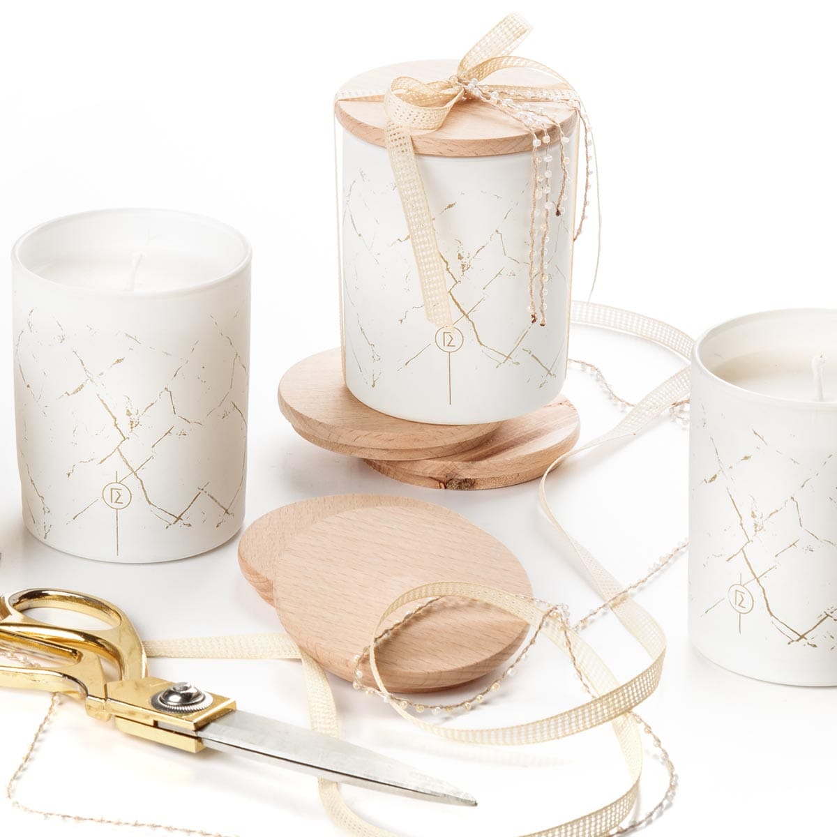 Λευκά κεριά με ξύλινα καπάκια και διακοσμητική κορδέλα.