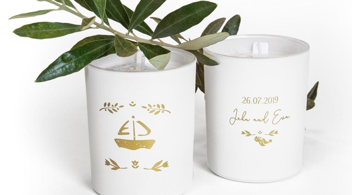 Λευκά κεράκια με σχέδια και πράσινα φύλλα.