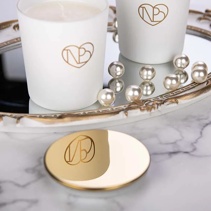 Λευκά κεριά και πέρλες πάνω σε δίσκο.