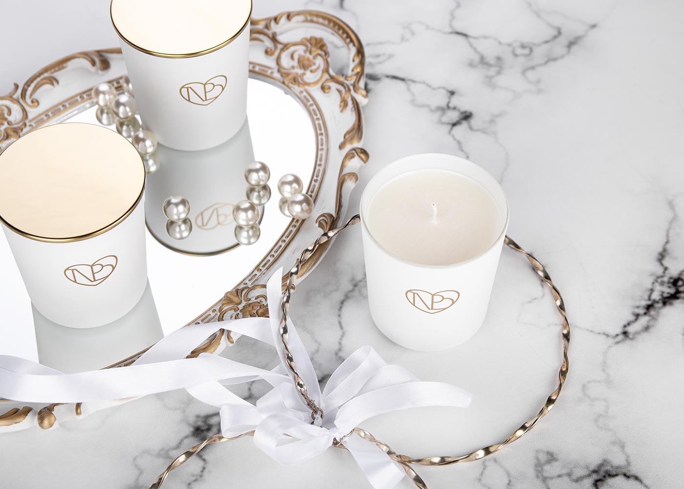 Άσπρο κερί με κορδέλα σε μαρμάρινο φόντο.