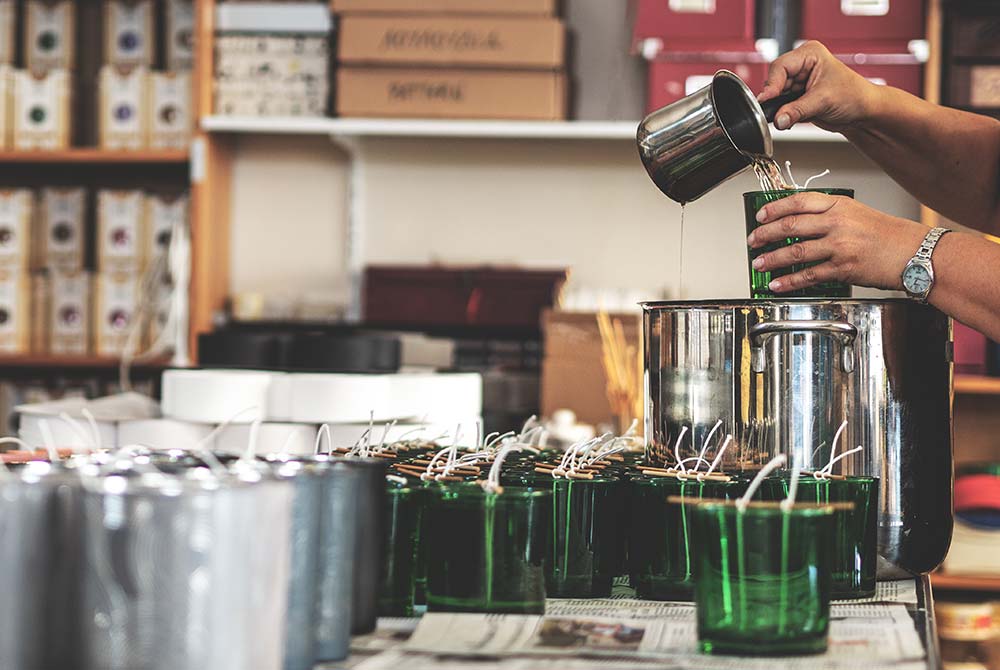 Άτομο φτιάχνει κεριά στο εργαστήριο.