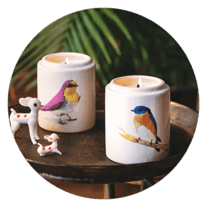 Δύο κεριά με σχέδια πουλιών σε δίσκο.