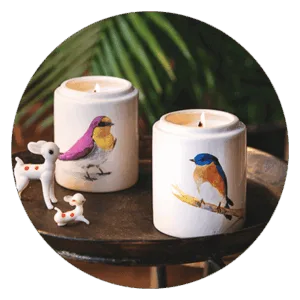 Δύο κεριά με σχέδια πουλιών σε δίσκο.