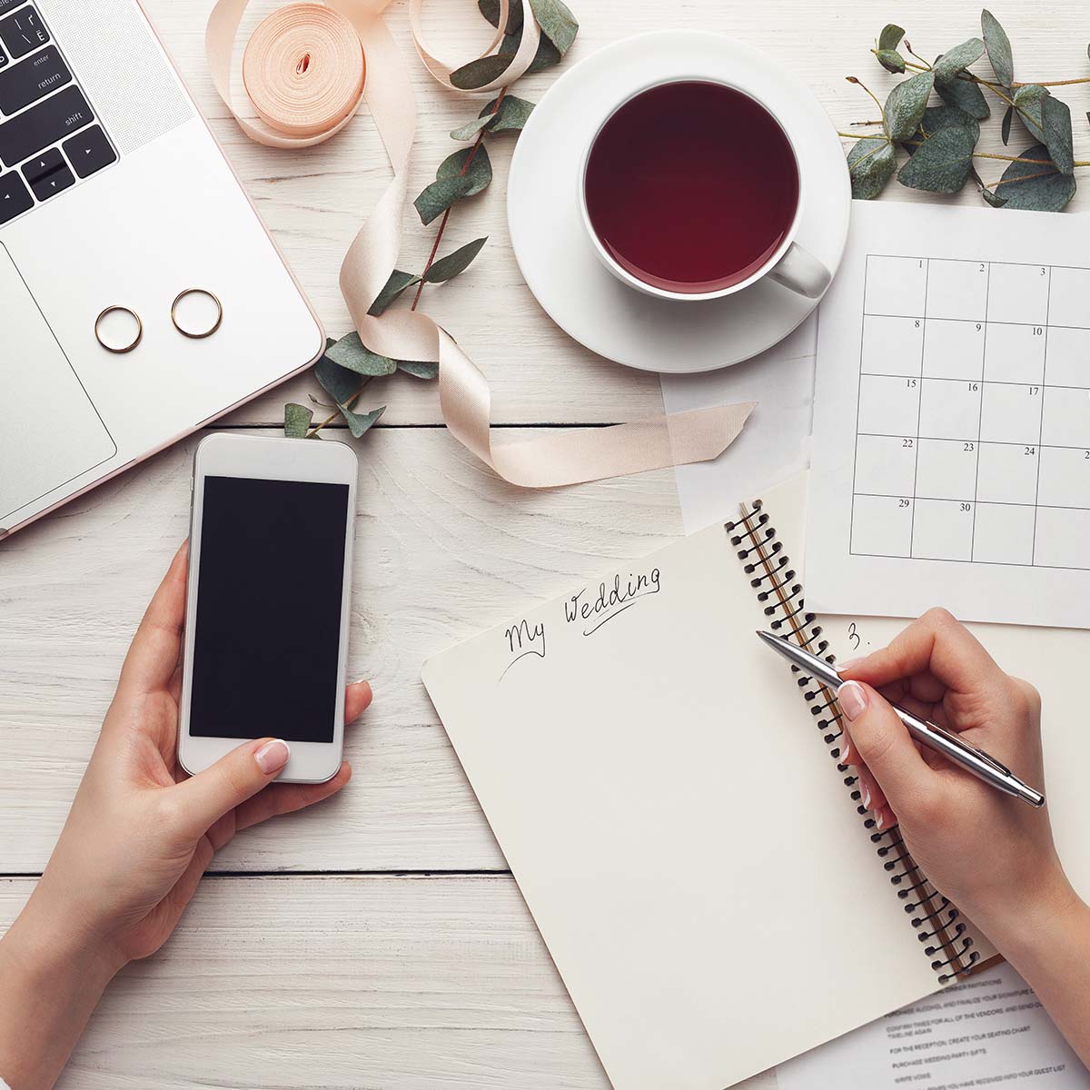 Wedding planner κρατάει σημειώσεις οργάνωσης γάμου, προετοιμάζοντας την παραγγελία custom μπομπονιέρων και premium b2b αρωματικών κεριών.