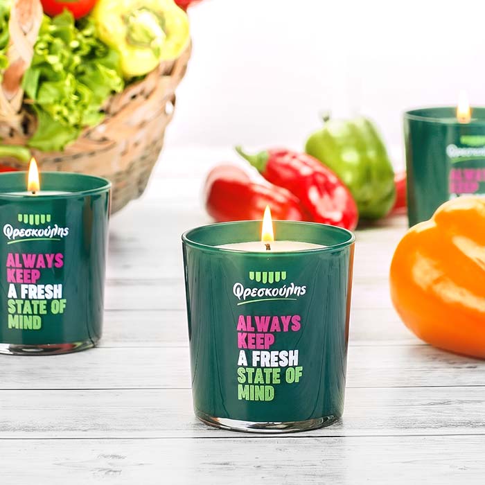 Αναμμένα custom αρωματικά κεριά Nancy's Candles σε πράσινο γυάλινο δοχείο για το εταιρικό δώρο της Eurocatering Φρεσκούλης.